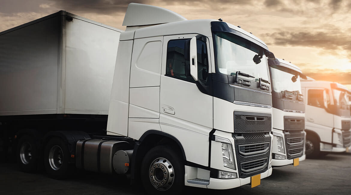 White semi-truck parked on a dusty road.