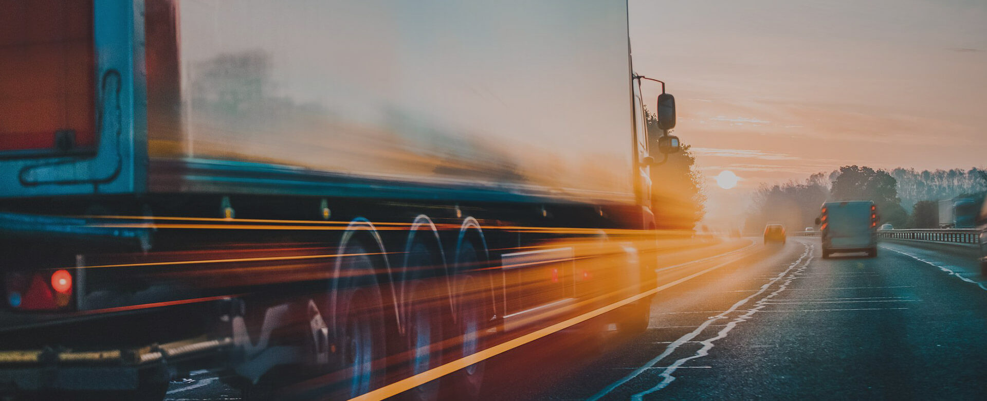 Blurred motion of a truck on a road during sunset.
