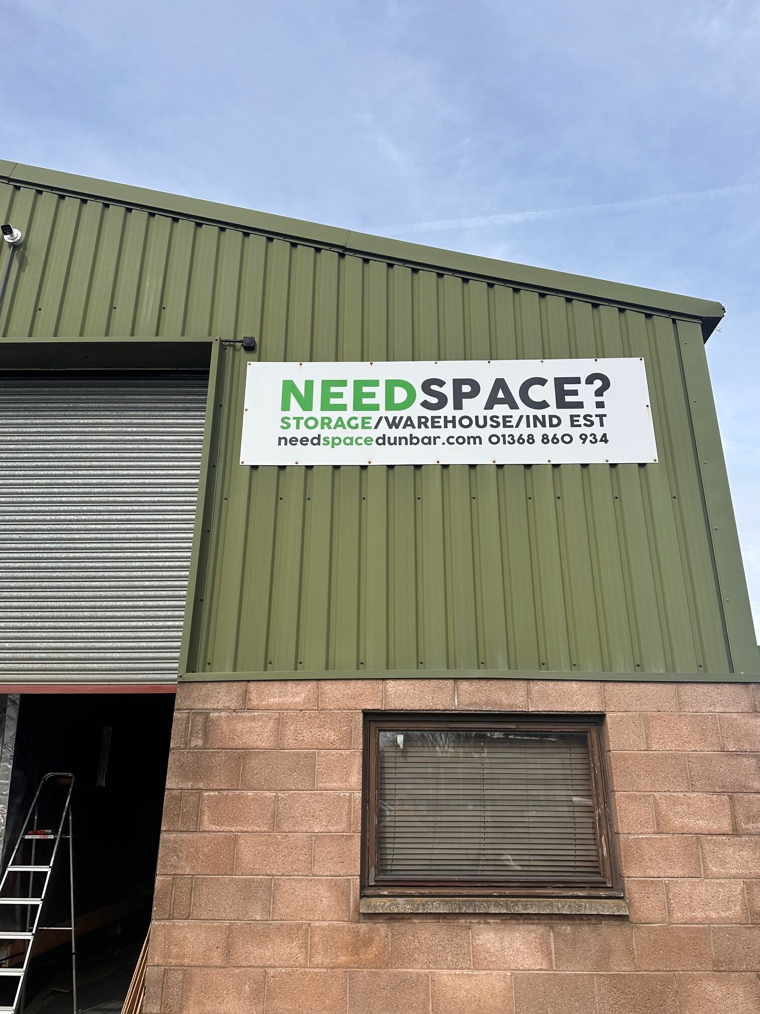 A warehouse with a sign advertising storage space for rent.