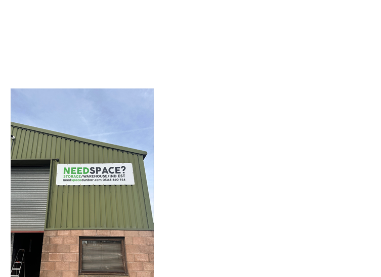 A green building with a 'Need Space?' sign offering storage units for rent.
